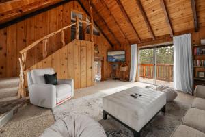 ein Wohnzimmer mit Sofa und Tisch in der Unterkunft The Fawnskin Hideaway, HUGE Backyard, BBQ & Patio! in Fawnskin