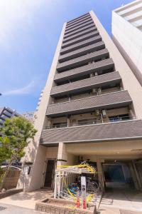 a tallartment building with a crane in front of it at Well-rent 名古屋丸の内 in Nagoya