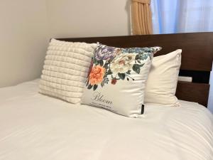 a pillow with a flower pattern on a bed at Casa Stella 10 by Liaison in Osaka