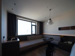 a living room with a couch and a window at Atour Hotel Dalian Zhongshan Plaza Lu Xun Road in Dalian