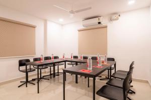 una sala de conferencias con mesas y sillas y un proyector en Treebo De Alphabet Gachibowli, en Hyderabad