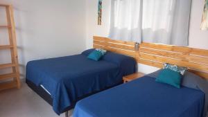 a room with two beds with blue sheets and a window at Casa Lua in Prado +30 photos