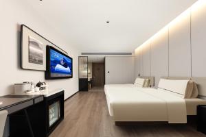 TV a/nebo společenská místnost v ubytování Atour Hotel Wuxi Taikeyuan Zhenze Road + 11 fotografií