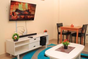 a living room with a tv and a table at Comfy one bedroom in Membly Ruiru in Ruiru +11 photos