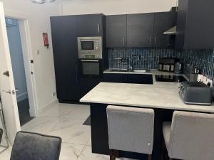 a kitchen with black cabinets and a counter top at Albert House in Airdrie
