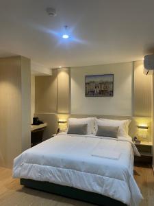 a bedroom with a large bed with white sheets and pillows at Kawi Jaya Hotel in Nagoya