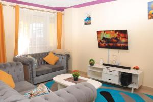 a living room with a couch and a tv at Comfy one bedroom in Membly Ruiru in Ruiru