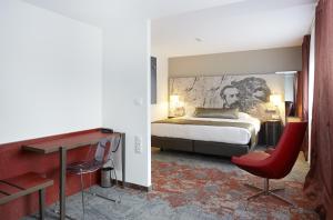 a bedroom with a bed and a desk and a chair at Mercure Belfort Centre in Belfort