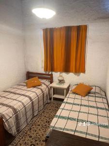 two beds in a small room with a window at Áfricano in Barra de Valizas