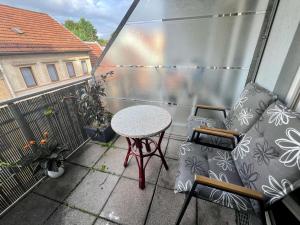 a small patio with a table and chairs on a balcony at PV Apartment in Eisenach