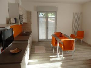 a kitchen with a table and orange chairs in a room at Casa Gemma in Malcesine