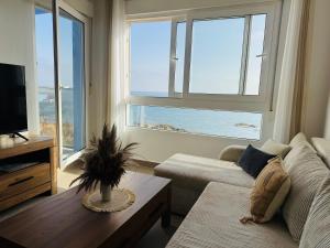 a living room with a couch and a table and a television at Apartment Sea Breeze I La Manga in La Manga del Mar Menor