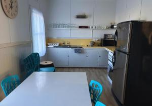 a kitchen with a refrigerator and a table and chairs at Stanley Heritage House in Stanley