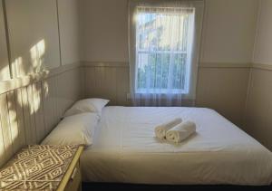 two beds in a bedroom with towels on them at Stanley Heritage House in Stanley