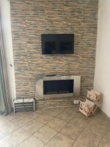 ein Flachbildfernseher, der an einer Ziegelwand montiert ist in der Unterkunft Charming House in Vittoria in Vittoria
