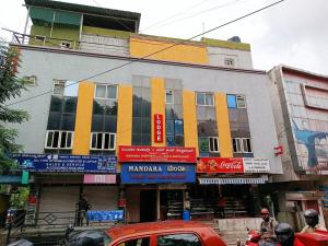 a building on a busy city street with cars at Mandara Comforts Hotel in Bengaluru