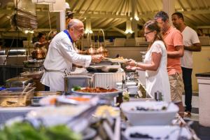 a man and a woman in a kitchen preparing food at Adaaran Club Rannalhi - All Inclusive - 45 Minutes away from Male by Speedboat in South Male Atoll