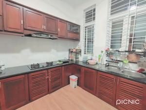a kitchen with wooden cabinets and a sink and a counter at Paradies Homestay in Hue