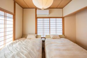 two beds in a room with two windows at Infinity Setouchi in Mihara