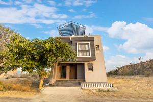 una piccola casa con un albero di fronte di Alaya Stays 4 BHK with Pvt Plunge pool - Lumbini a Udaipur