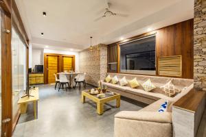 un soggiorno con un divano e un tavolo di Alaya Stays 4 BHK with Pvt Plunge pool - Lumbini a Udaipur Altre 47 foto
