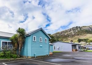 a blue building in a parking lot with a mountain in the background at Stanley Heritage House in Stanley