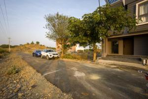 una strada con due auto parcheggiate accanto a un edificio di Alaya Stays 4 BHK with Pvt Plunge pool - Lumbini a Udaipur