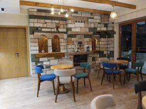 a restaurant with tables and chairs and a stone wall at Bujtina Çupa in Klos