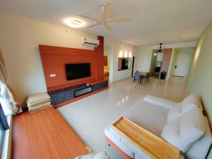 a living room with a white couch and a flat screen tv at The Apple Nice View Condo 16 in Melaka