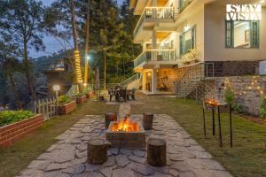 eine Feuerstelle im Hof eines Hauses in der Unterkunft StayVista at Pinecrest Manor - Outdoor Jacuzzi in Kasauli