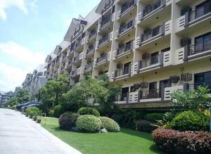 a large apartment building with bushes in front of it at The Redwoods SM Fairview with Balcony in Manila