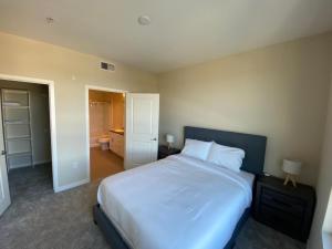 a bedroom with a large white bed and a bathroom at Central Apartment in Los Angeles