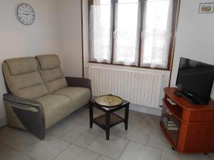 a living room with a couch and a tv and a table at Gîte indépendant, 2 ch, proche A5, jardin clos, garage - FR-1-611-111 in Richebourg