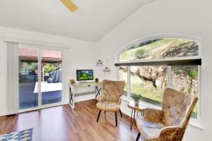 ein Wohnzimmer mit einem Schreibtisch und 2 Stühlen in der Unterkunft Villa near Yosemite & bass lake w/Hot Tub/EVcharge in Oakhurst