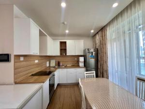 a kitchen with white cabinets and a refrigerator at Comfortable 3 bedroom apartment in Ulaanbaatar in Ulaanbaatar