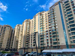 a large apartment building with cars parked in a parking lot at Comfortable 3 bedroom apartment in Ulaanbaatar in Ulaanbaatar