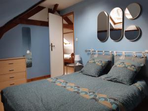 una camera da letto con un letto e specchi sul muro di "La mouette rieuse" - De la convivialité à 2mn de la mer - 48m2 - 6max a Étretat