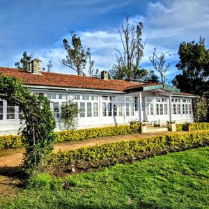 a large white building with a red roof at Milhaven Crest in Kodaikānāl
