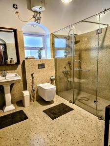 a bathroom with a shower and a toilet and a sink at Milhaven Crest in Kodaikānāl