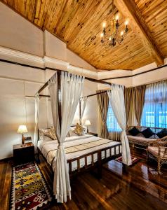 a bedroom with a bed with curtains and a chandelier at Milhaven Crest in Kodaikānāl +38 photos