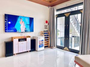 a living room with a tv on the wall at Villa Đà Lạt Trung Nghĩa in Ấp Ða Lợi +50 photos