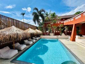 a swimming pool with straw umbrellas next to a building at Rosa Mar in Lamai