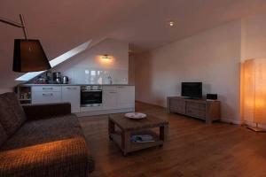 un salon avec un canapé et une télévision dans l'établissement Wohnung-3, à Nebel