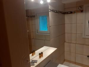 ein Badezimmer mit Dusche, Waschbecken und Spiegel in der Unterkunft City Studio Kavala in Kavala