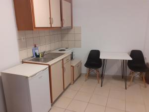 eine Küche mit einer Spüle sowie einem Tisch und Stühlen in der Unterkunft City Studio Kavala in Kavala