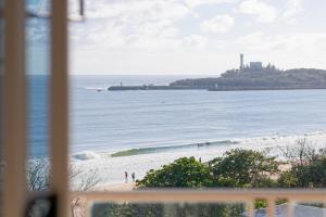 uma vista de uma praia de uma janela em Sandbox Mooloolaba Beach em Mooloolaba