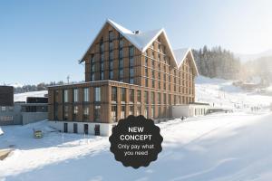 a large building with a sign in the snow at Stoos Lodge in Stoos