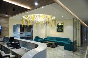 a lobby with blue couches and a chandelier at Hotel Ratan Elite in Bijainagar