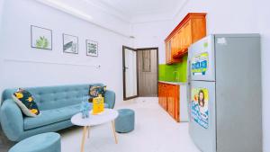 a living room with a couch and a table and a refrigerator at 46 An Hòa, Mỗ lao in Hanoi