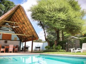 a swimming pool with a pavilion next to a house at Apartments @ 125 in Gaborone